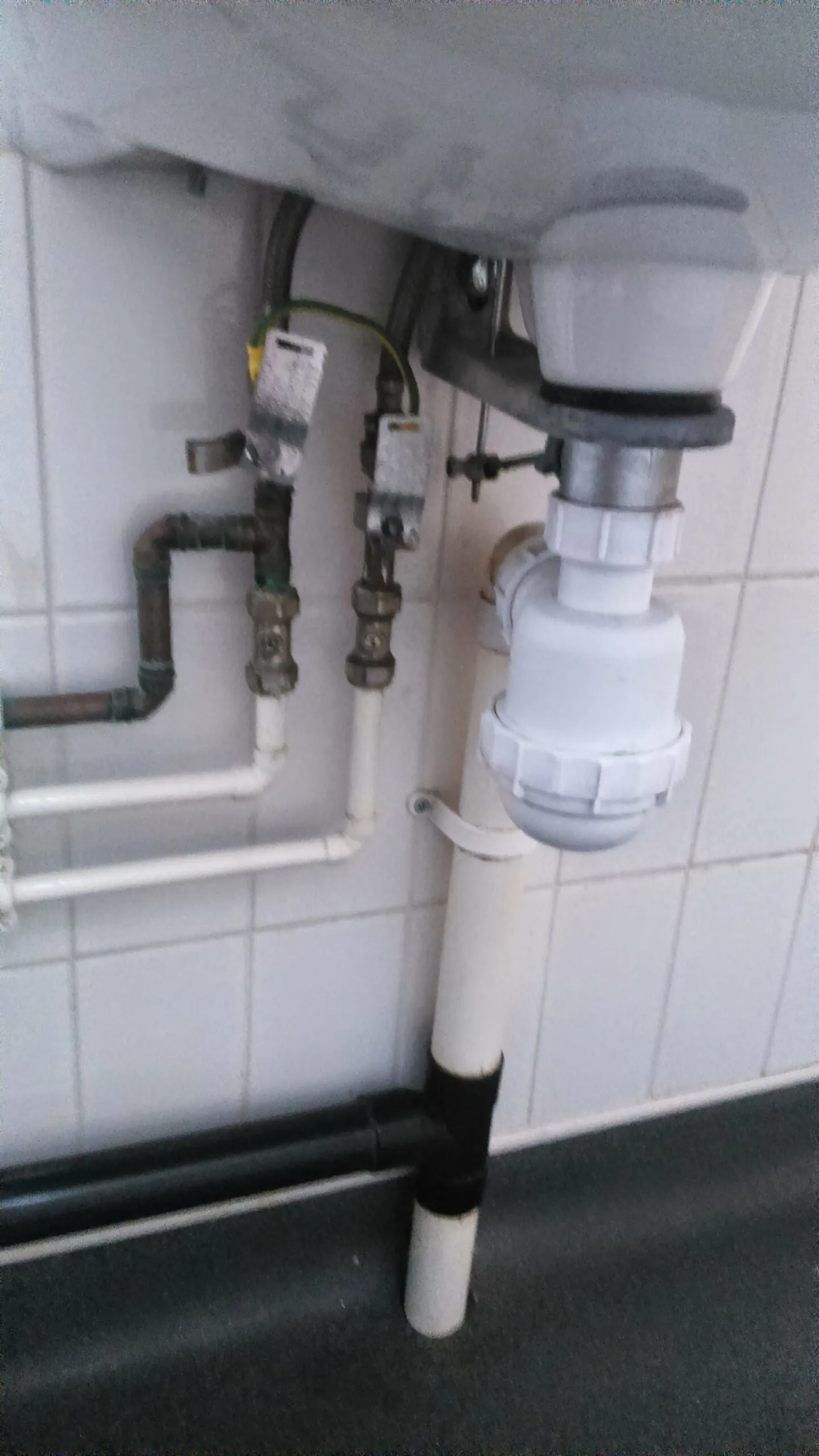 The plumbing and pipework underneath a bathroom sink