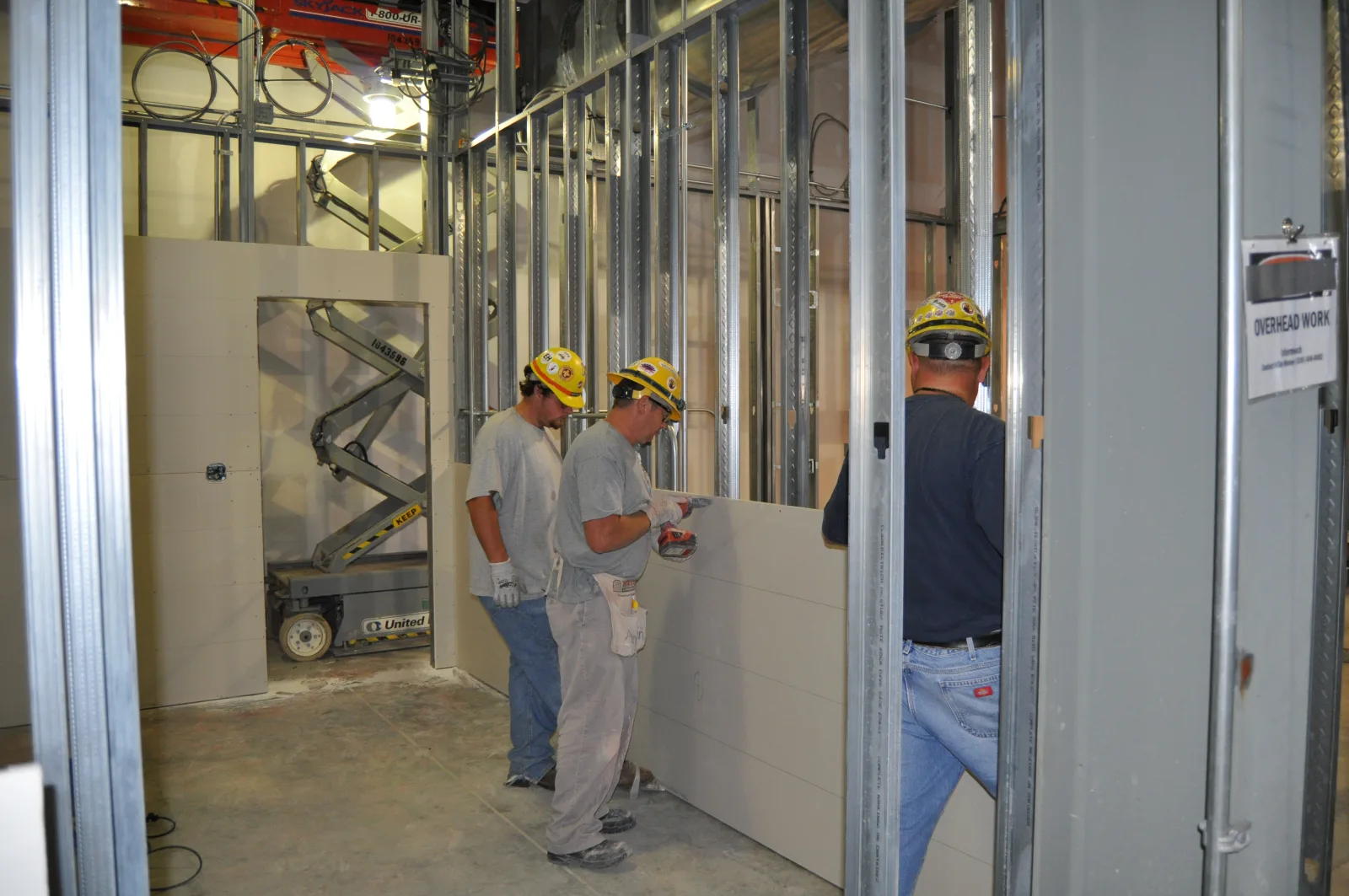 Blue Grass Chemical Agent-Destruction Pilot Plant craft workers safely fasten sheetrock to metal wall studs inside the Control and Support Building.