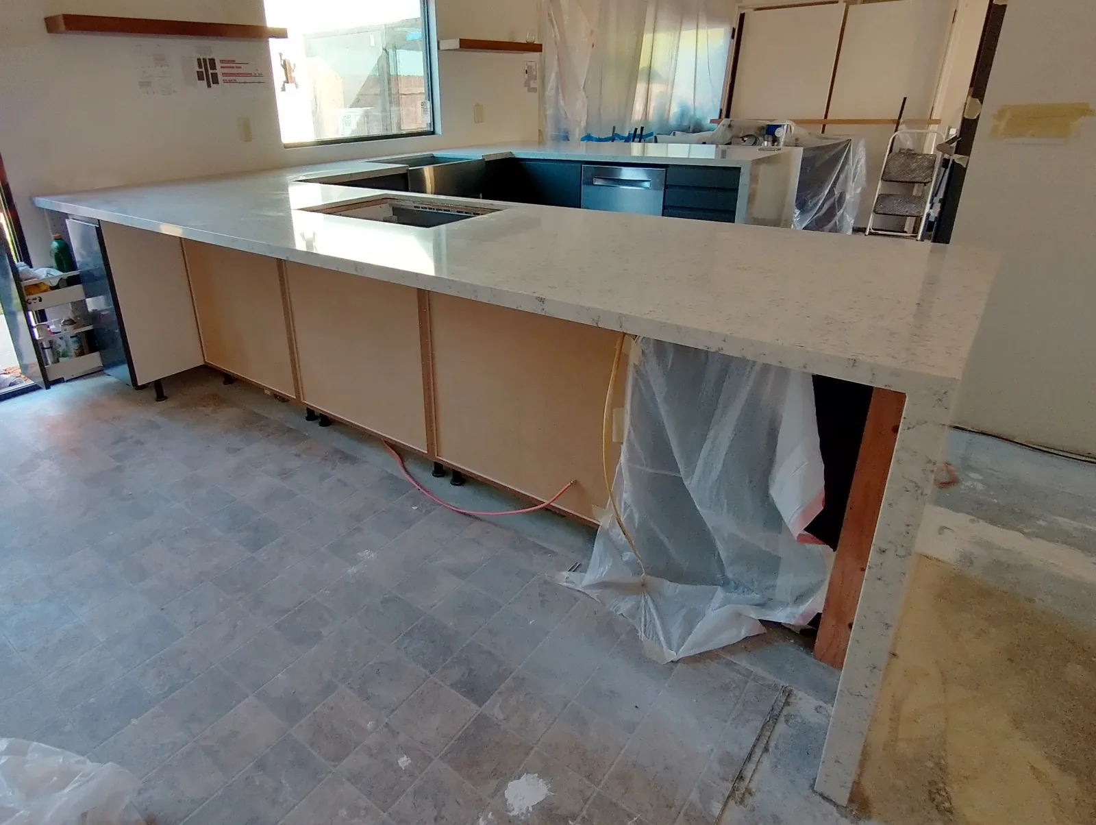 This is a quartz countertop, installed onto Ikea ("Sektion") kitchen cabinets, shown immediately after installation.