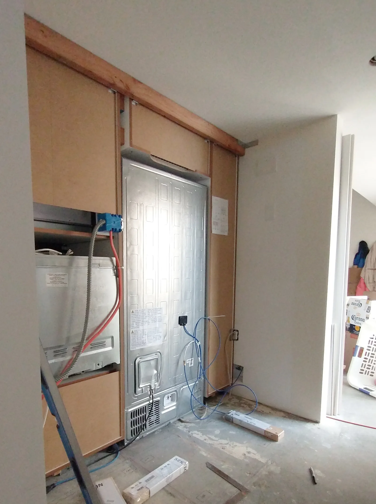 This image is part of a series of photos that show how a space that was too narrow to accommodate the planned row of cabinets was extended by trimming one of the walls. 1/2" drywall was replaced by 1/8" hardboard.