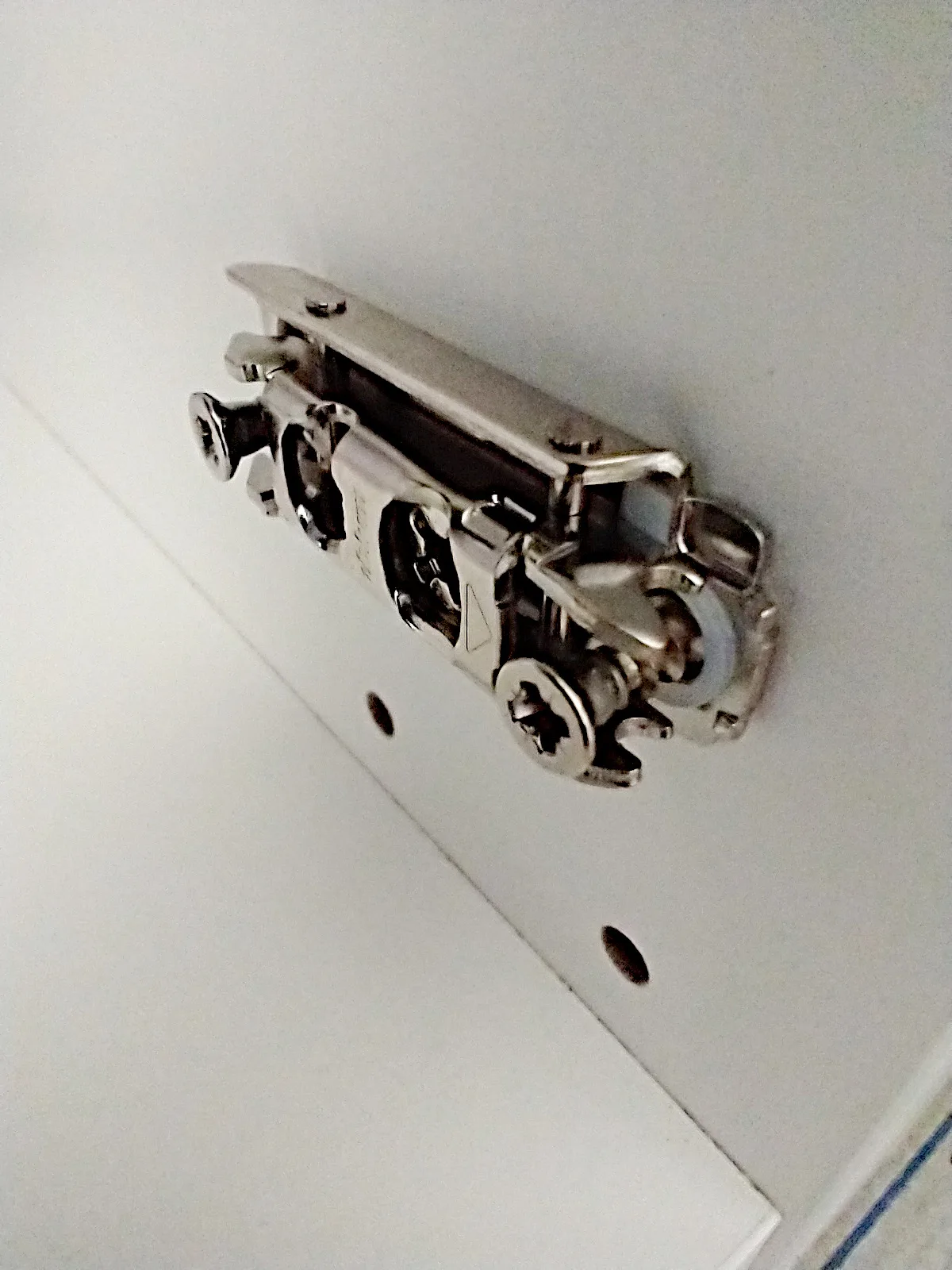 This image is part of a series of photos showing types of Ikea's "Utrusta" hinges (for the kitchen cabinet system "Sektion") or their parts