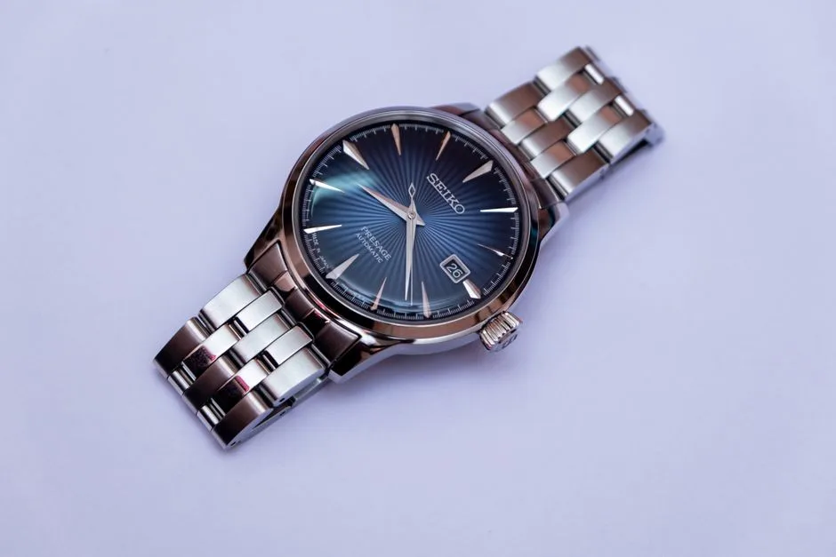 Stylish stainless steel wristwatch with blue dial on a soft background, showcasing craftsmanship and timekeeping.