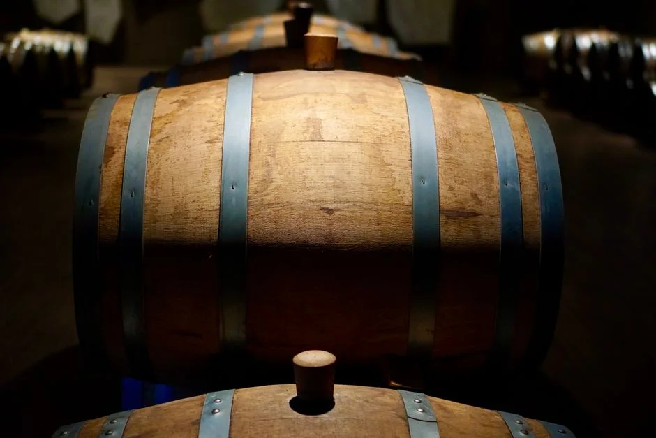 Barrels in a shadowed winery cellar, perfect for wine aging imagery.
