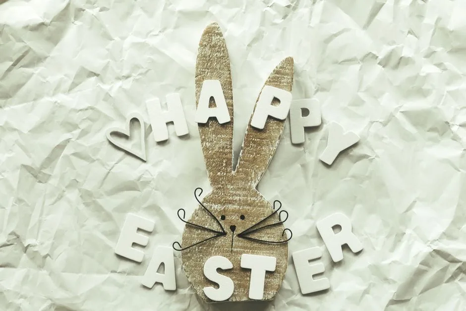 Handmade Easter bunny decoration with letters forming 'Happy Easter' on crinkled paper.