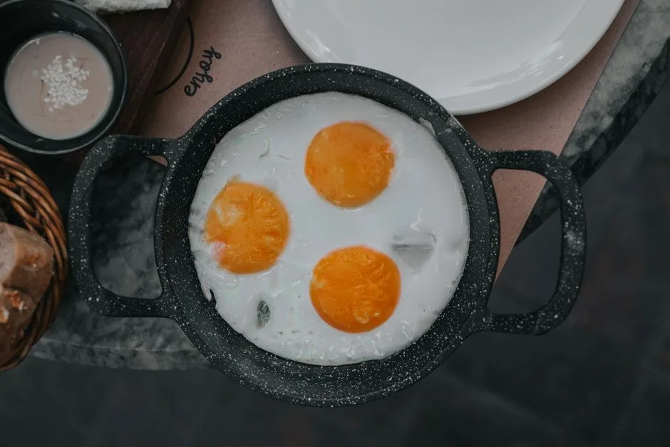 Top view of delicious fried eggs in a pan, perfect for a cozy breakfast setting.
