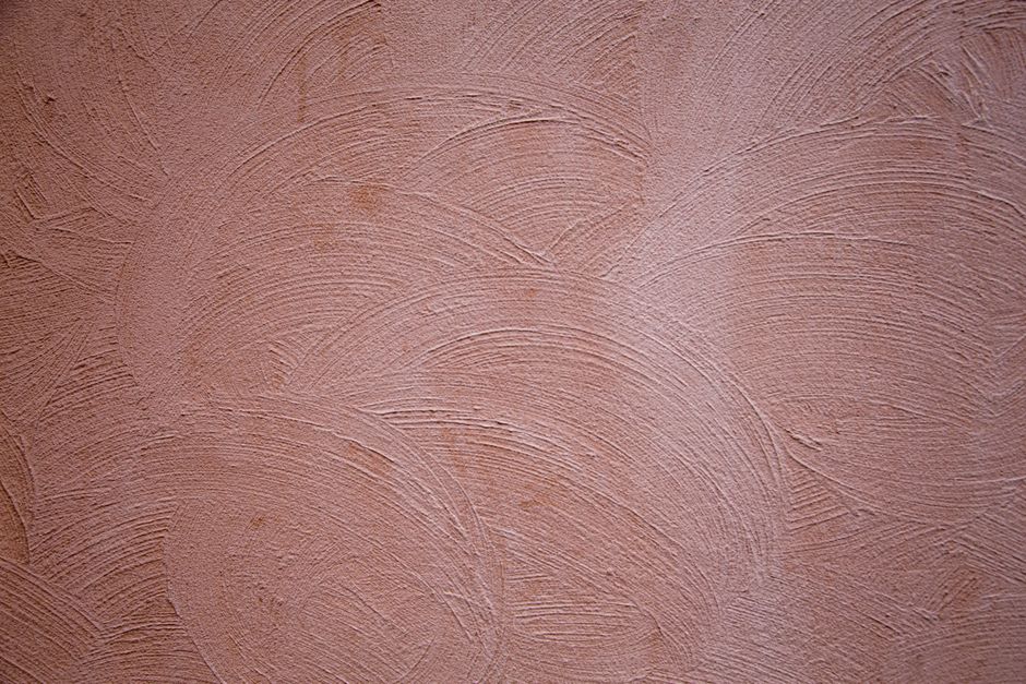 Close-up of a textured concrete wall with artistic brushed patterns.
