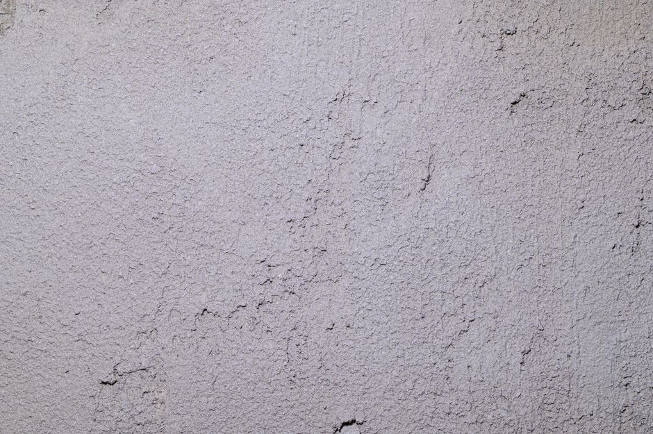 Close-up of a gray stucco wall showing rough, textured surface ideal for backgrounds.