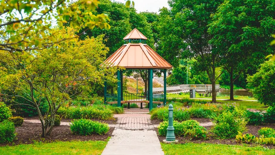Captivating gazebo in a lush garden surrounded by vibrant greenery and pathways.