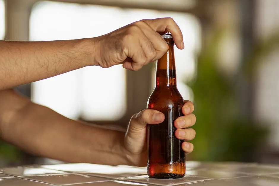 Hands opening a beer bottle, showcasing the moment of anticipation.