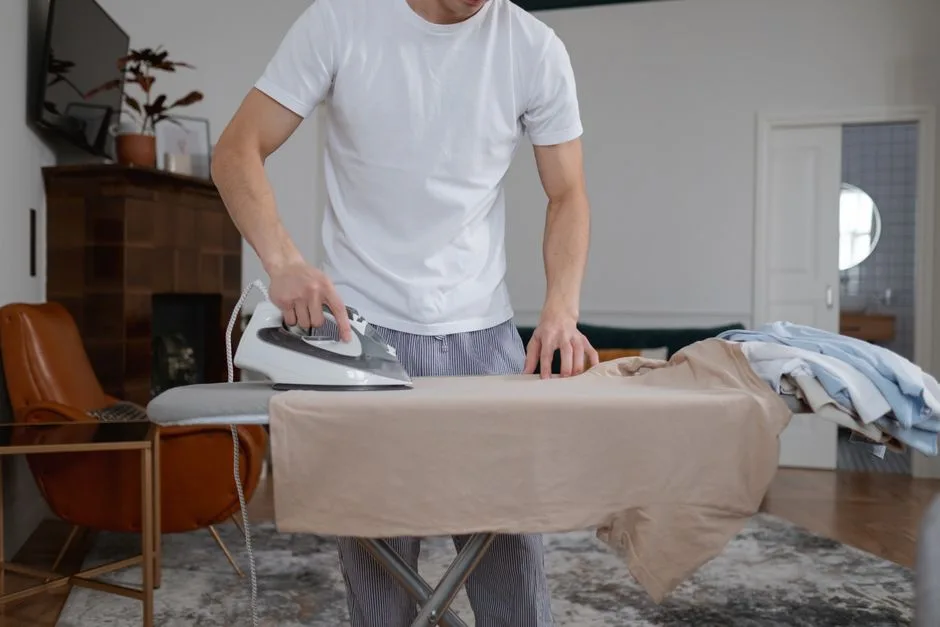 Man performing ironing chores in a modern home interior setting.