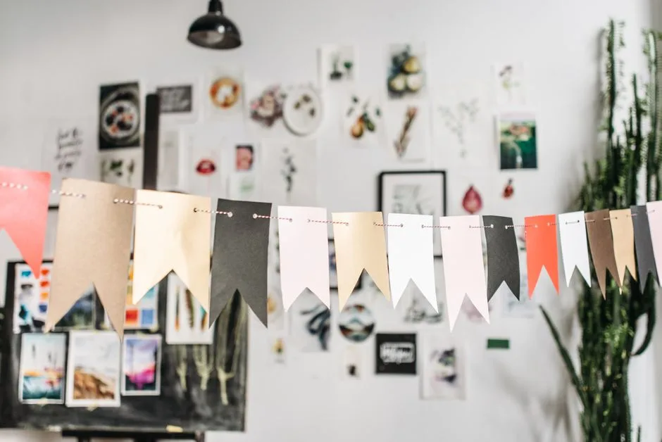 Artistic studio interior with decorative flag garlands and creative artworks on display.