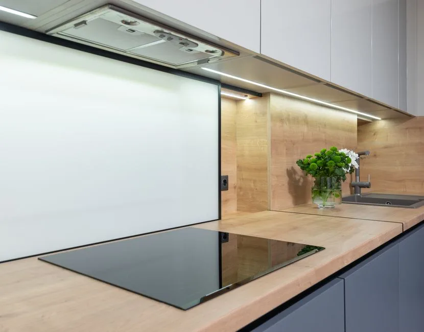 Built in cook top under hood and cupboard in contemporary kitchen with flowers in vase