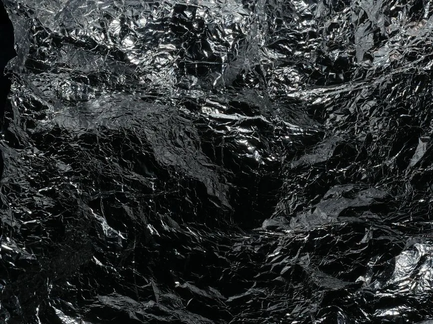 Reflective crumpled silver foil texture, ideal for backgrounds or abstract designs.