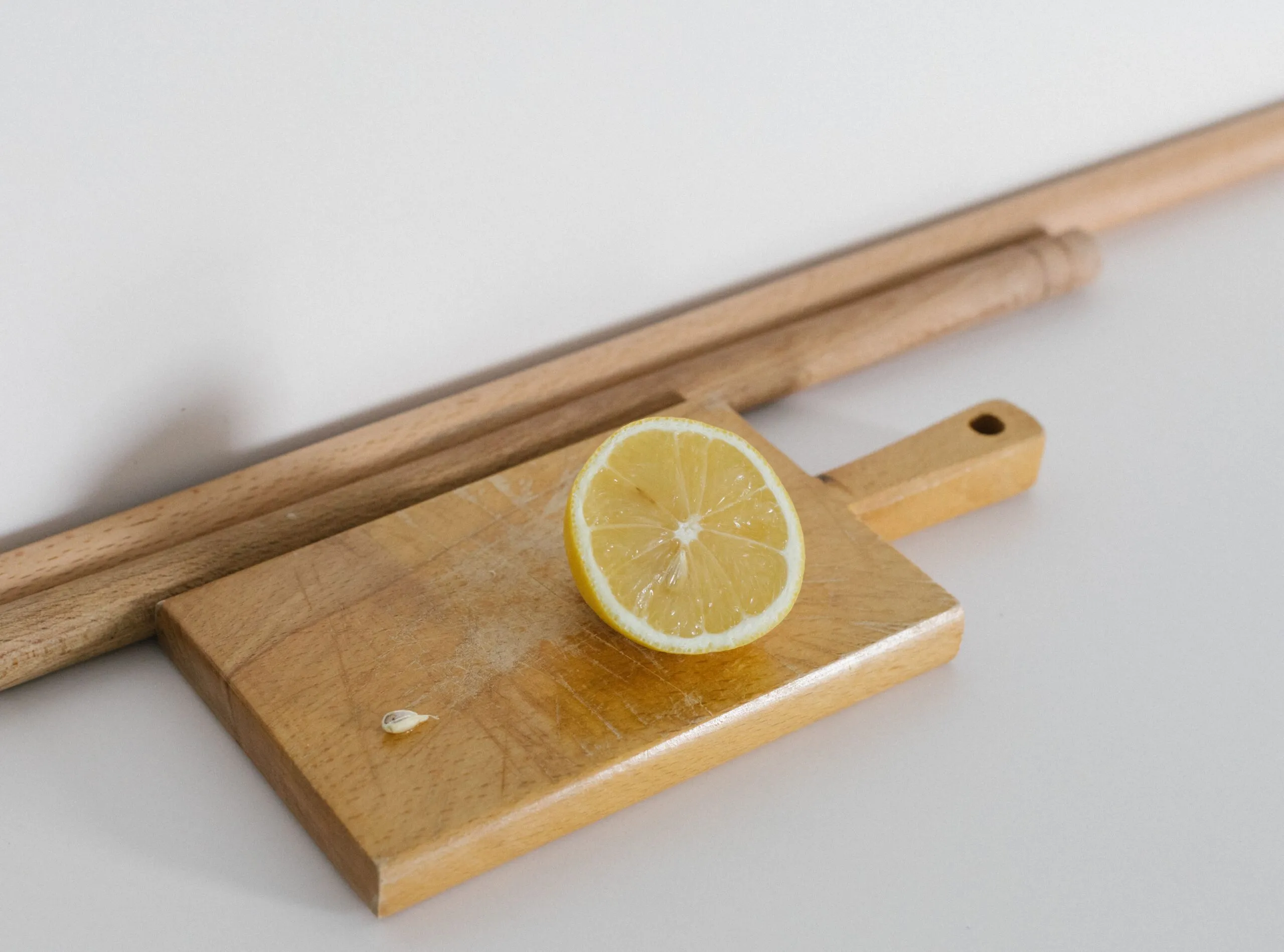 A fresh lemon slice on a wooden chopping board, perfect for culinary themes.