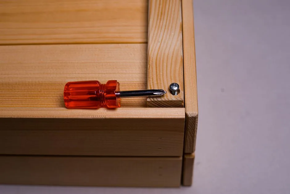 A detailed shot of a screwdriver inserted into a screw on a wooden box. Ideal for DIY themes.