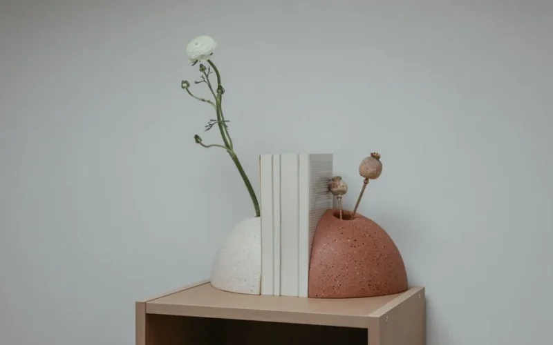 Elegant minimalist bookends with flowers on a wooden shelf. Perfect for interior decor.