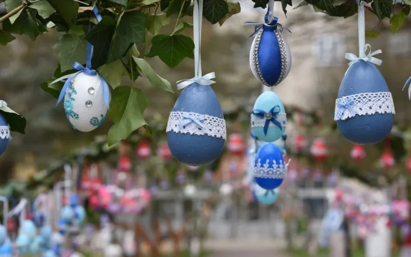 Beautifully decorated Easter eggs hanging on a branch, creating a festive outdoor display.