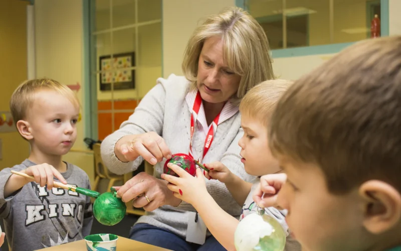 Hollyanne Milley paints Christmas tree ornaments with children at the Cody Child Development Center Nov. 12 on the Fort Myer portion of Joint Base Myer-Henderson Hall. Milley and Holly Dailey, both residents of JBM-HH, visited the center to decorate Christmas ornaments with two preschool classes. (Joint Base Myer-Henderson Hall PAO photo by Delonte Harrod) Unit: Joint Base Myer-Henderson Hall