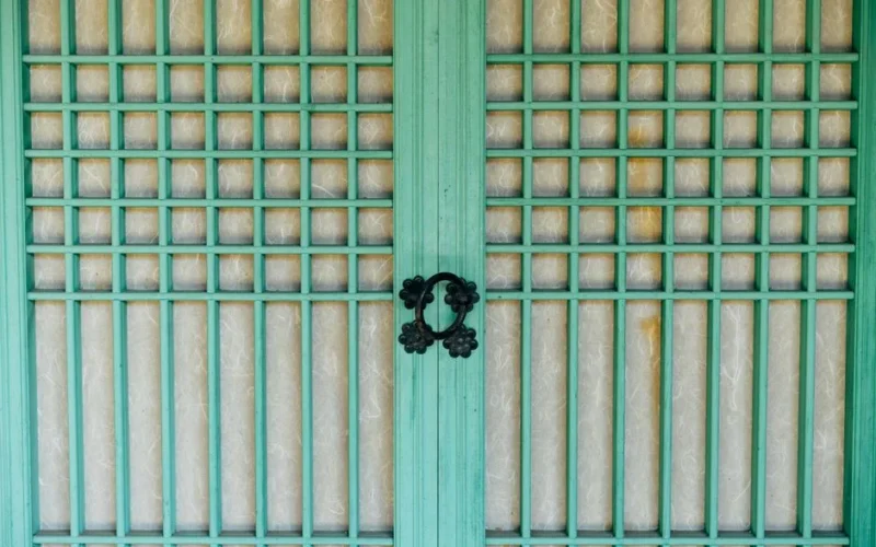 Close-up of a traditional wooden door featuring green latticework in Seoul, South Korea.
