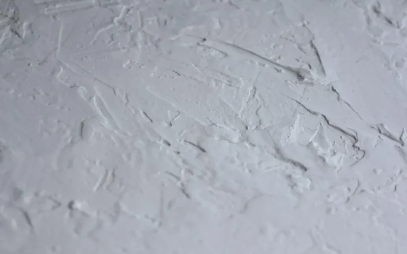 Close-up shot of a textured white plaster surface with rough details.