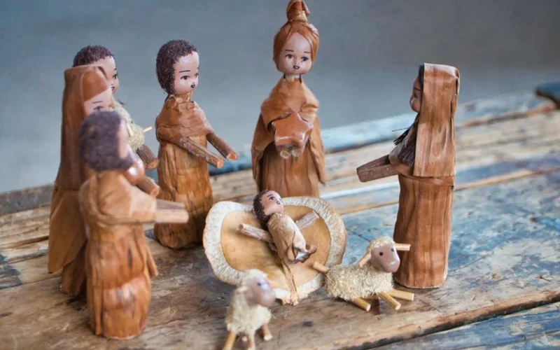 Charming handmade nativity scene depicting Baby Jesus, Mary, and others in a traditional wooden style.