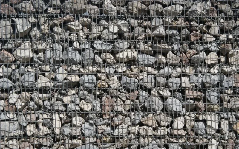 Detailed view of stones encapsulated within a sturdy wire mesh structure, showcasing texture.