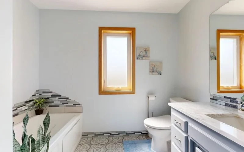 Bright modern bathroom featuring a tub, skylight, and elegant decor.