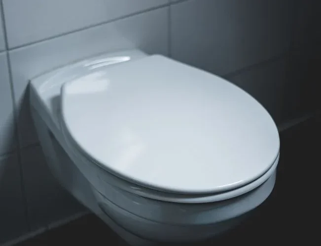 A sleek and modern white toilet in a well-lit minimalist bathroom setting.
