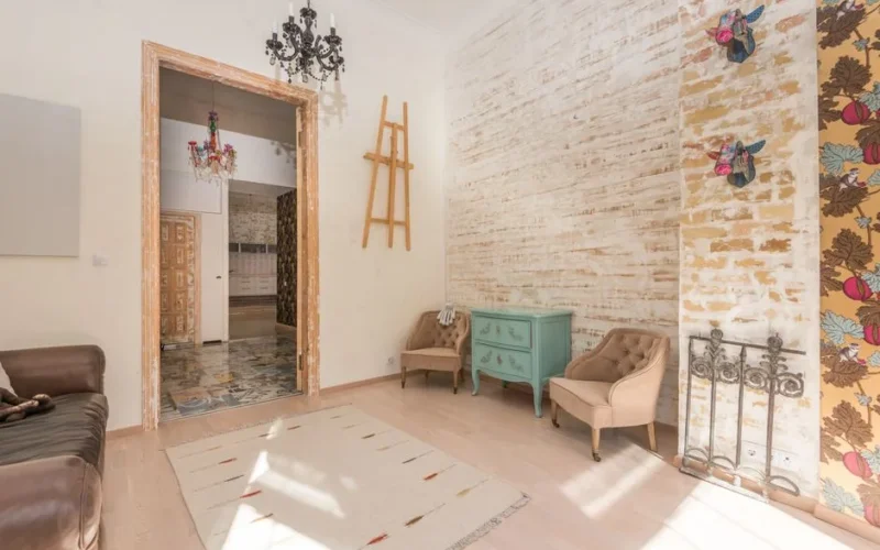 Bright vintage-style living room featuring retro decor, brick walls, and colorful chandeliers.