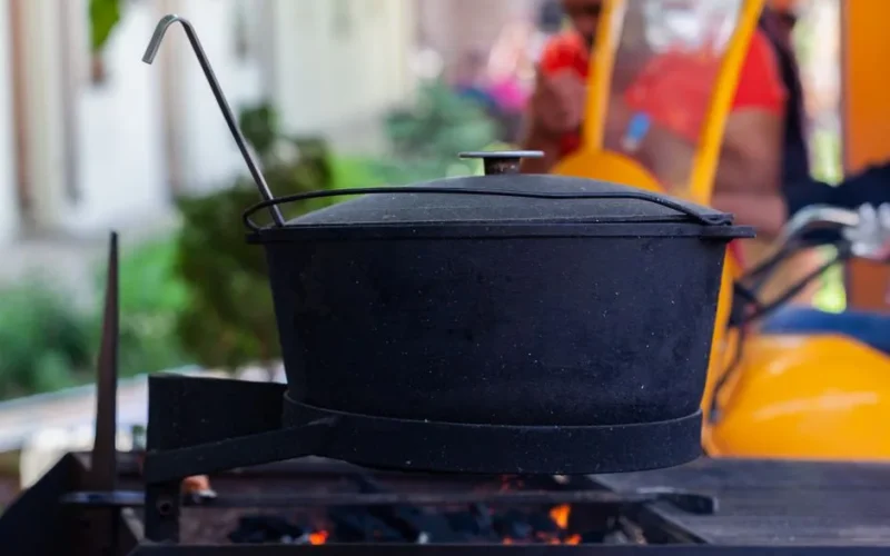 A large black pot on an open flame, perfect for outdoor cooking or camping scenes.