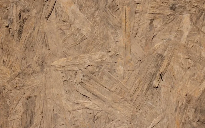 Close-up of a rough textured oriented strand board (OSB) wooden surface.