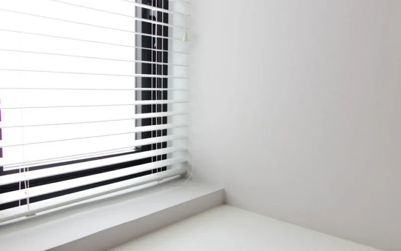 Bright minimalist interior with white window blinds and smooth wall, perfect for modern design.