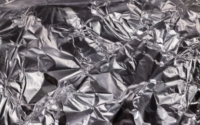 Close-up of shiny crumpled aluminum foil showcasing metallic wrinkled texture.
