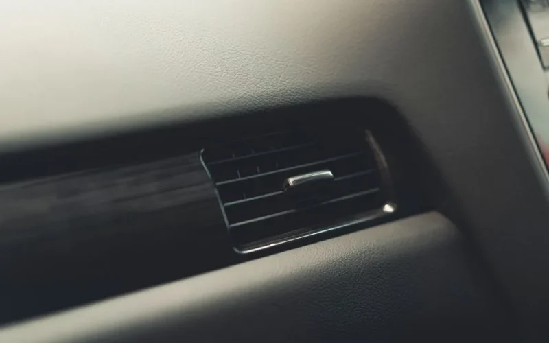 Detailed view of a car air vent system, showcasing interior design and texture.