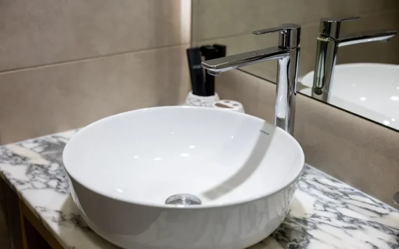 Stylish bathroom sink with a chrome faucet and marble countertop, ideal for contemporary interior design.