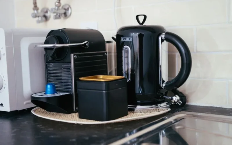Sleek black coffee maker and kettle on a modern kitchen countertop, ideal for brewing.