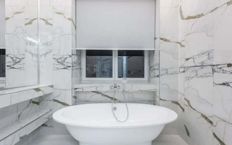 Modern bathroom featuring a luxurious marble design and a sleek freestanding bathtub.