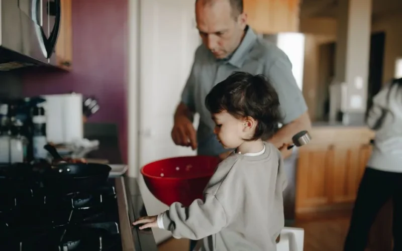 Father and child enjoying a cooking session together in the home kitchen.