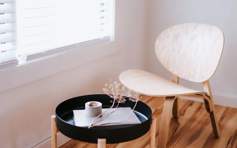Elegant Japandi style room with a wooden chair, round table, and decorative items.