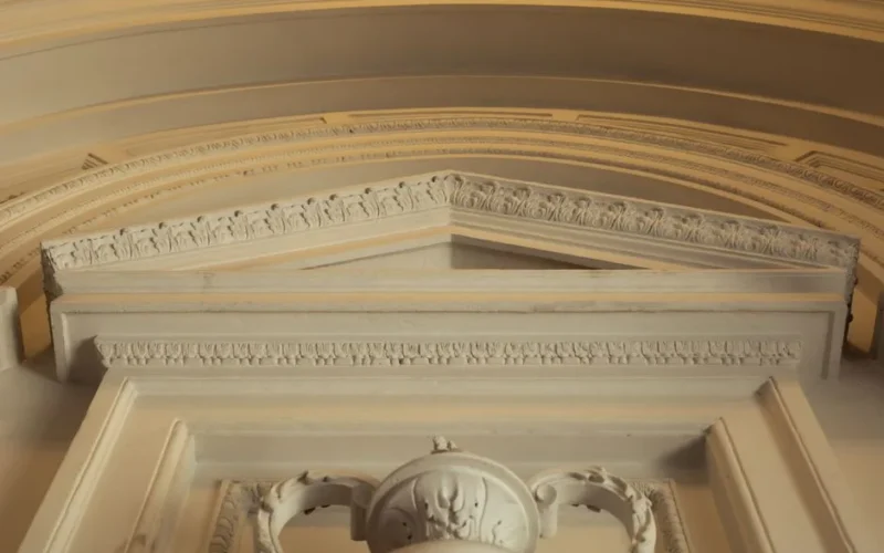 A detailed view of an ornate interior architectural design featuring intricate molding and craftsmanship.