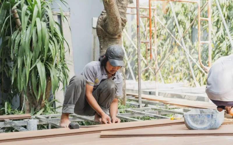 A skilled carpenter working with wooden planks outdoors in Hồ Chí Minh City.