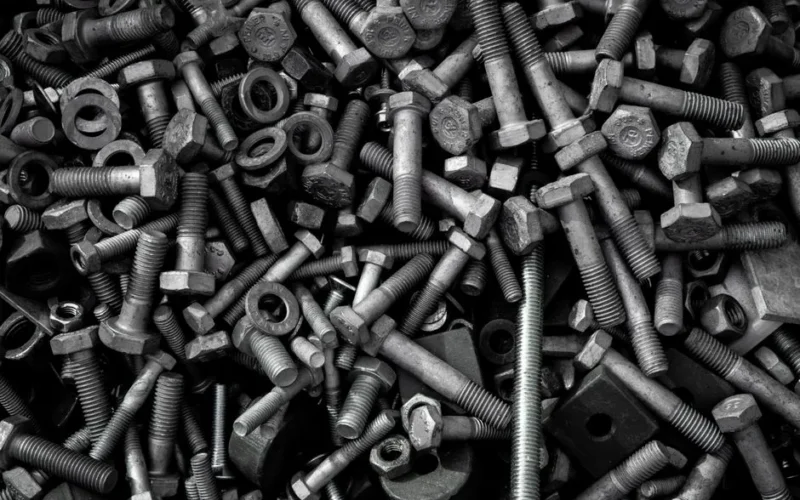 Detailed image of assorted industrial bolts and screws for recycling or mechanics.