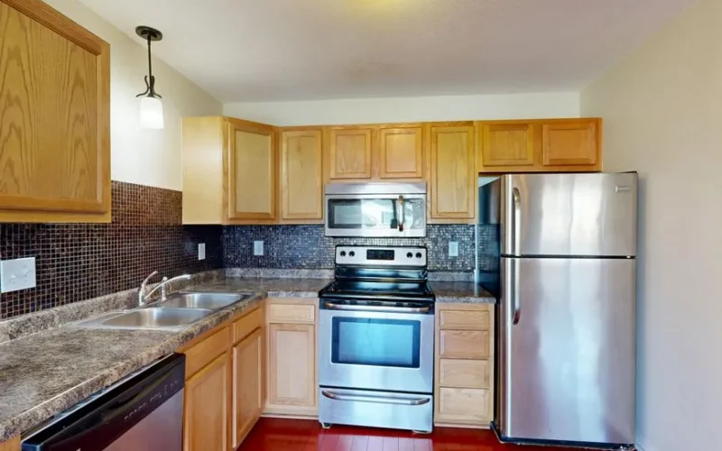 Contemporary kitchen featuring stainless steel appliances and wooden cabinetry.