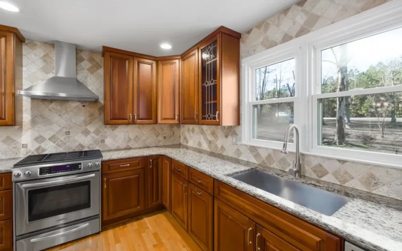 Spacious kitchen with granite countertops and natural light from large windows.