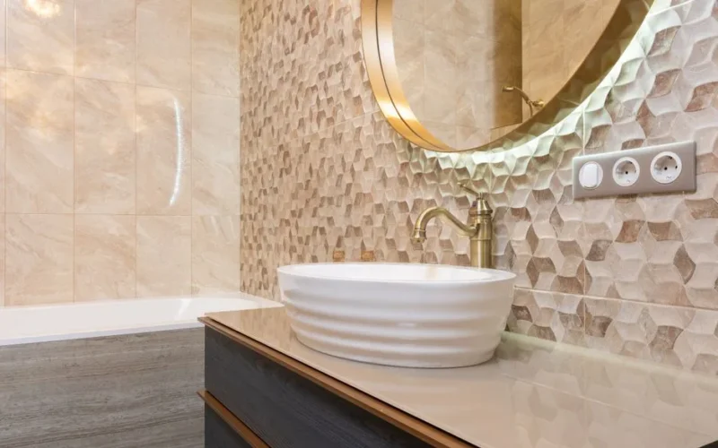 Interior of bright bathroom with sink with tap on cabinet under mirror next to bathtub