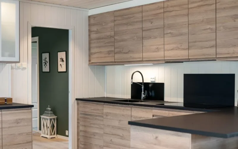 Sleek kitchen interior featuring wooden cabinets and black countertops.