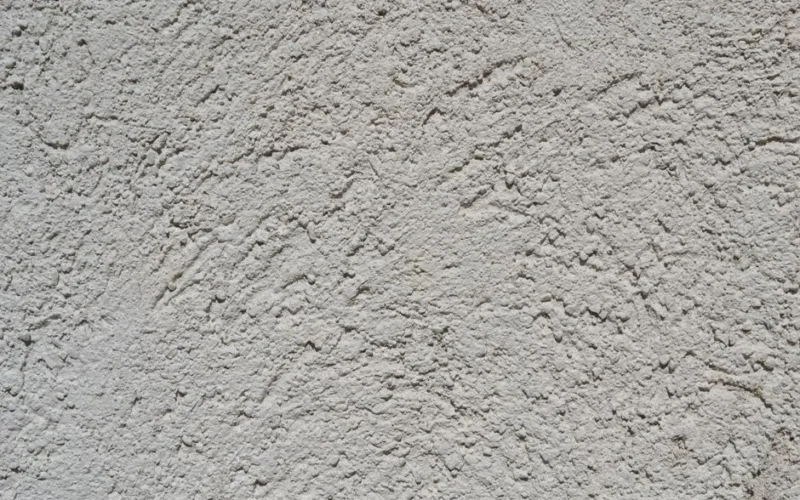 Close-up of a light gray stucco wall texture, ideal for backgrounds.