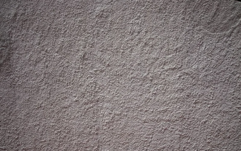 Close-up of a textured stucco wall showing detailed patterns and rough surface
