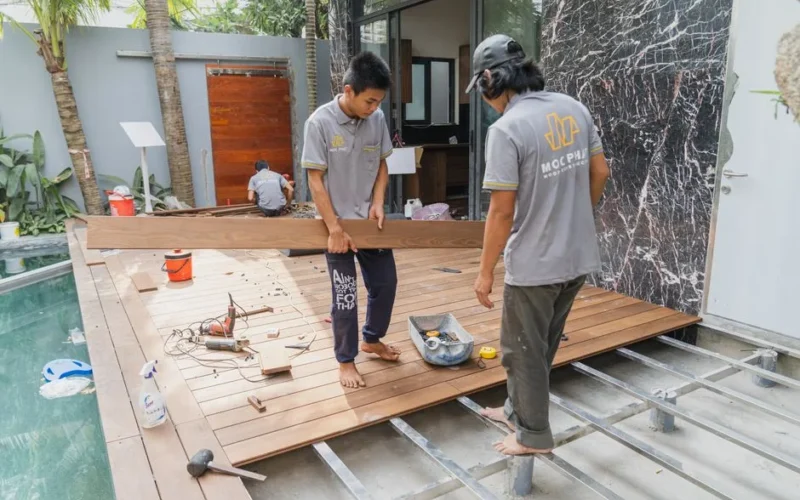 Carpenters working on a wooden floor installation in Hồ Chí Minh, Việt Nam.