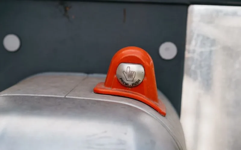 A detailed image of an orange industrial push button labeled 'Premi-Push.'